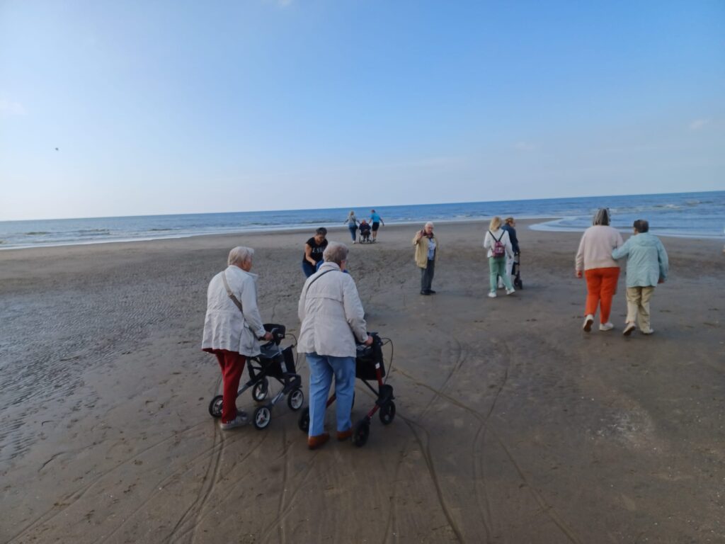 Gasten op het strand met rollator, rolstoel of aan de arm